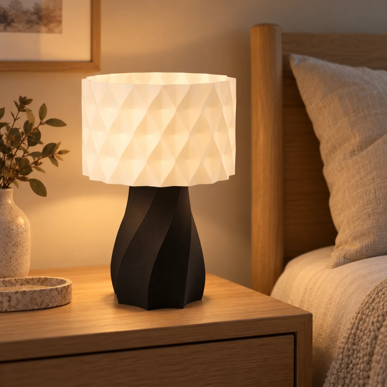 Pink Bnana Twirl Glow Table Lamp with black base illuminating a bedside table